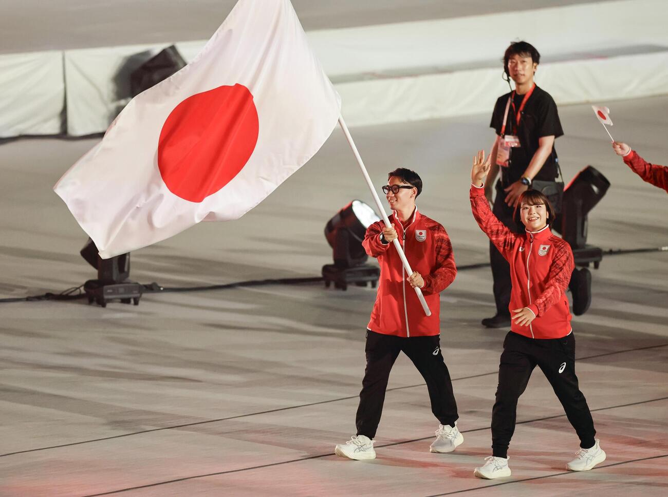アジア大会の開会式で、日の丸を手に入場行進する旗手の中村輪夢（左）と藤波朱理＝19日、パロマ瑞穂スタジアム