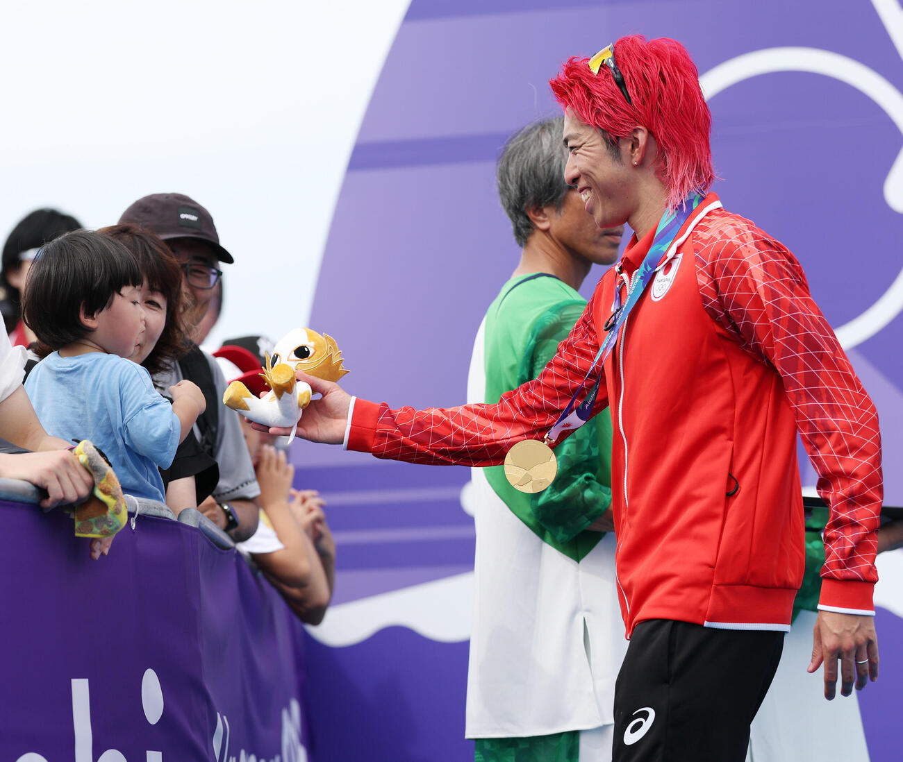 トライアスロン　優勝し金のホノホンをファンの子どもにプレゼントする北條巧（撮影・宮地輝）