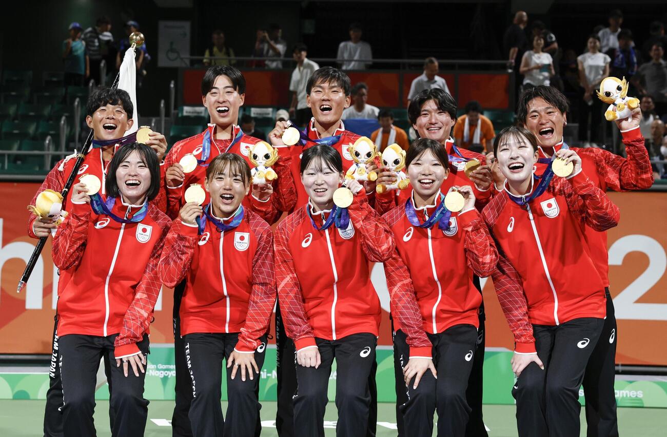 団体でそれぞれ優勝し、写真に納まる男女の選手たち＝名古屋市東山公園TC(共同)