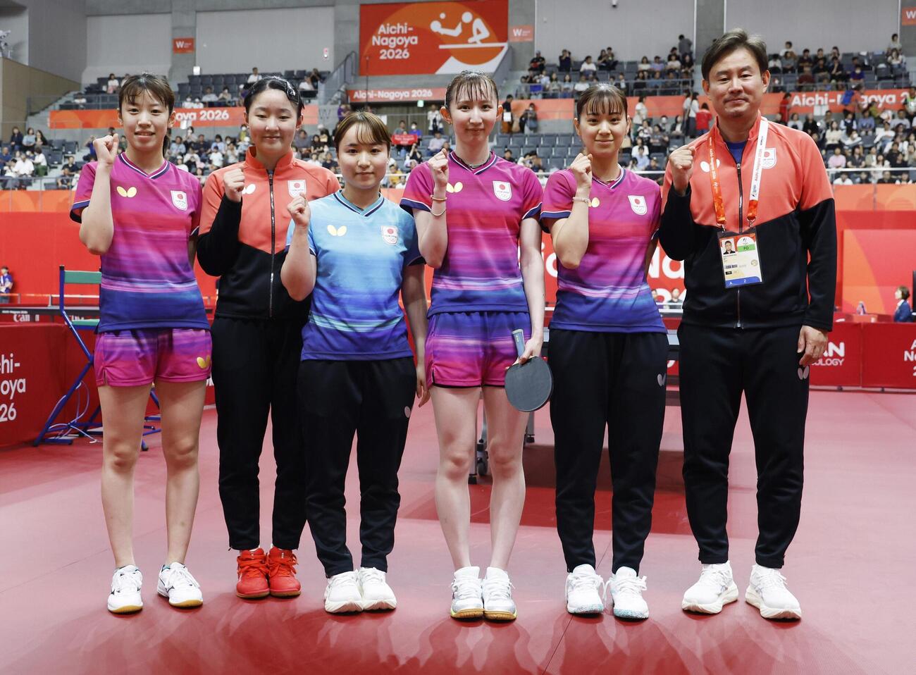 女子団体1次リーグでウズベキスタンに勝利し、ポーズをとる（左から）面手凜、張本美和、伊藤美誠、早田ひな、長崎美柚、中沢鋭監督＝豊田市総合体育館（共同）