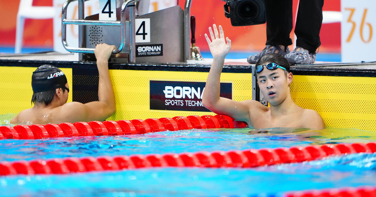 男子400メートル個人メドレー決勝　金メダルを獲得し、声援に応える小島夢貴。左は銀メダルの松下知之（撮影・鈴木みどり）