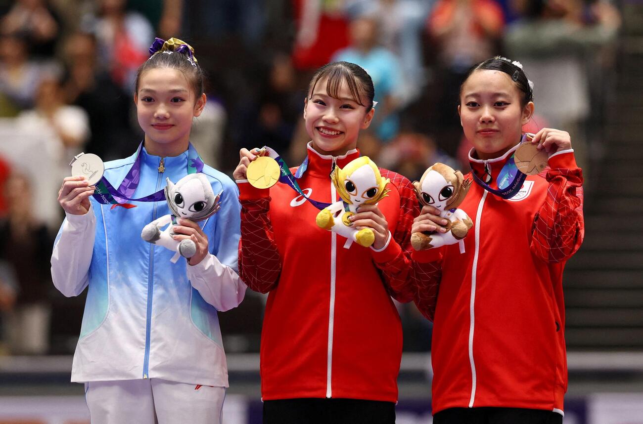 女子個人総合で優勝した杉原愛子（中央）は金メダルを手に笑顔（ロイター）