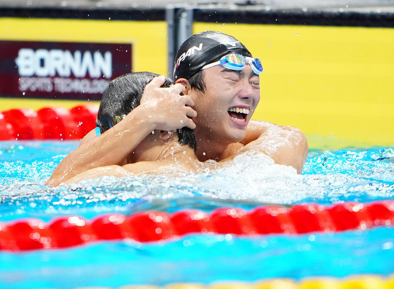 男子100メートルバタフライ決勝　金メダルを獲得した光永翔音（右）は銅メダルの松元克央と抱き合って喜ぶ（撮影・鈴木みどり）