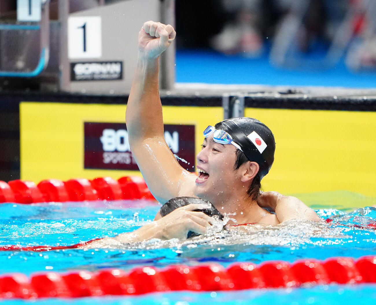 男子100メートルバタフライ決勝　金メダルを獲得した光永翔音はガッツポーズ。手前は銅メダルの松元克央（撮影・鈴木みどり）