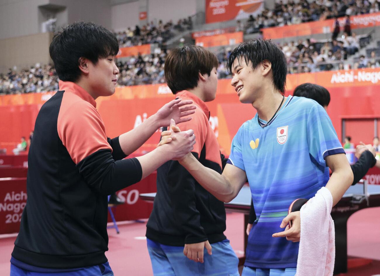 2026年9月23日、男子団体準決勝で韓国に勝利し、タッチを交わす張本智和（左）と戸上隼輔＝豊田市総合体育館（共同）