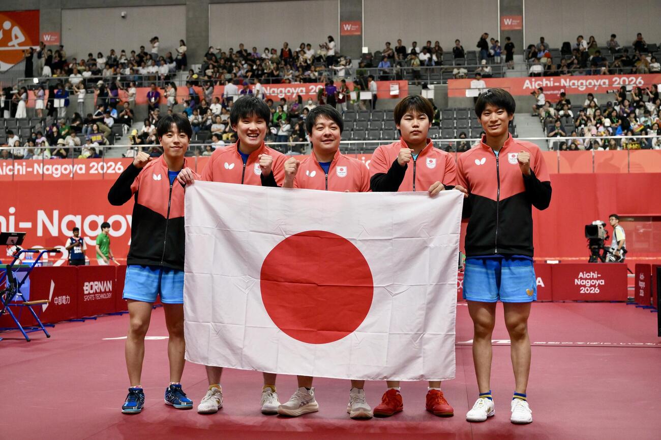 男子団体決勝　中国を破り優勝を決め日の丸を手に記念撮影する選手たち（撮影・滝沢徹郎）