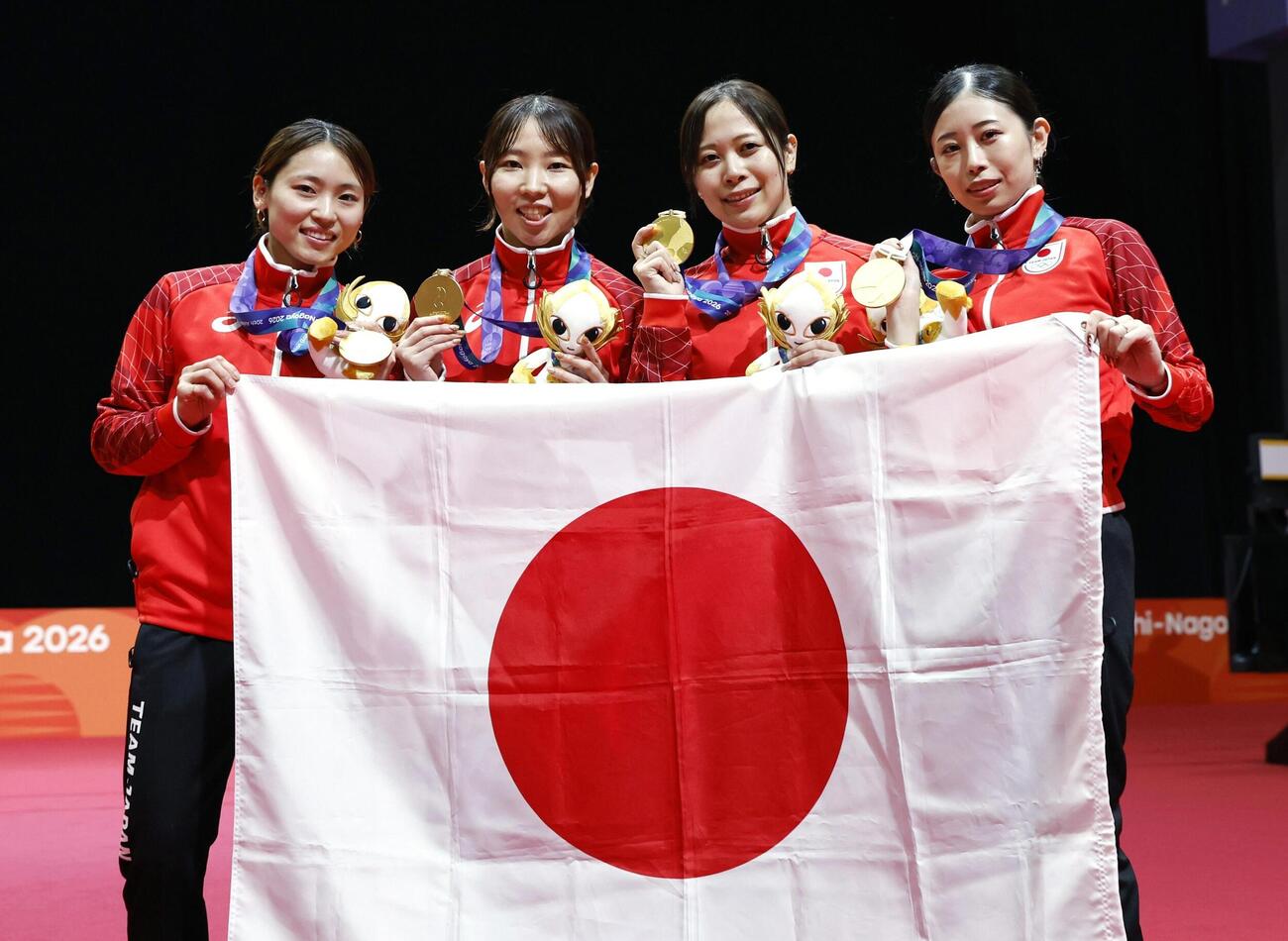 女子フルーレ団体で金メダルを獲得し、日の丸を掲げる（左から）東晟良、上野優佳、菊池小巻、辻すみれ＝愛知県国際展示場（共同）