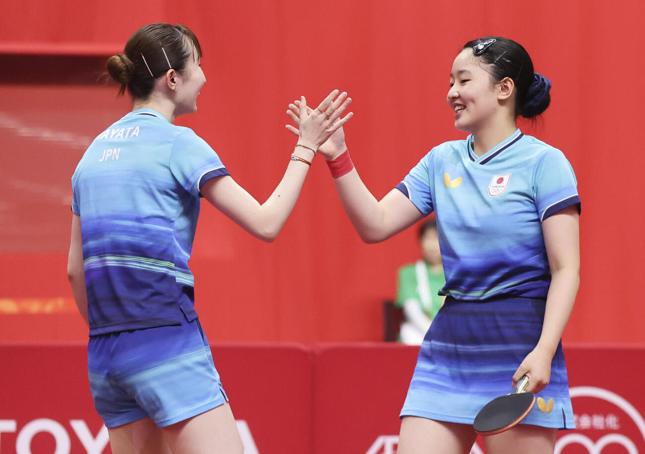 女子ダブルス準々決勝　中国ペアに勝利しタッチを交わす張本美和（右）、早田ひな組＝豊田市総合体育館（共同）