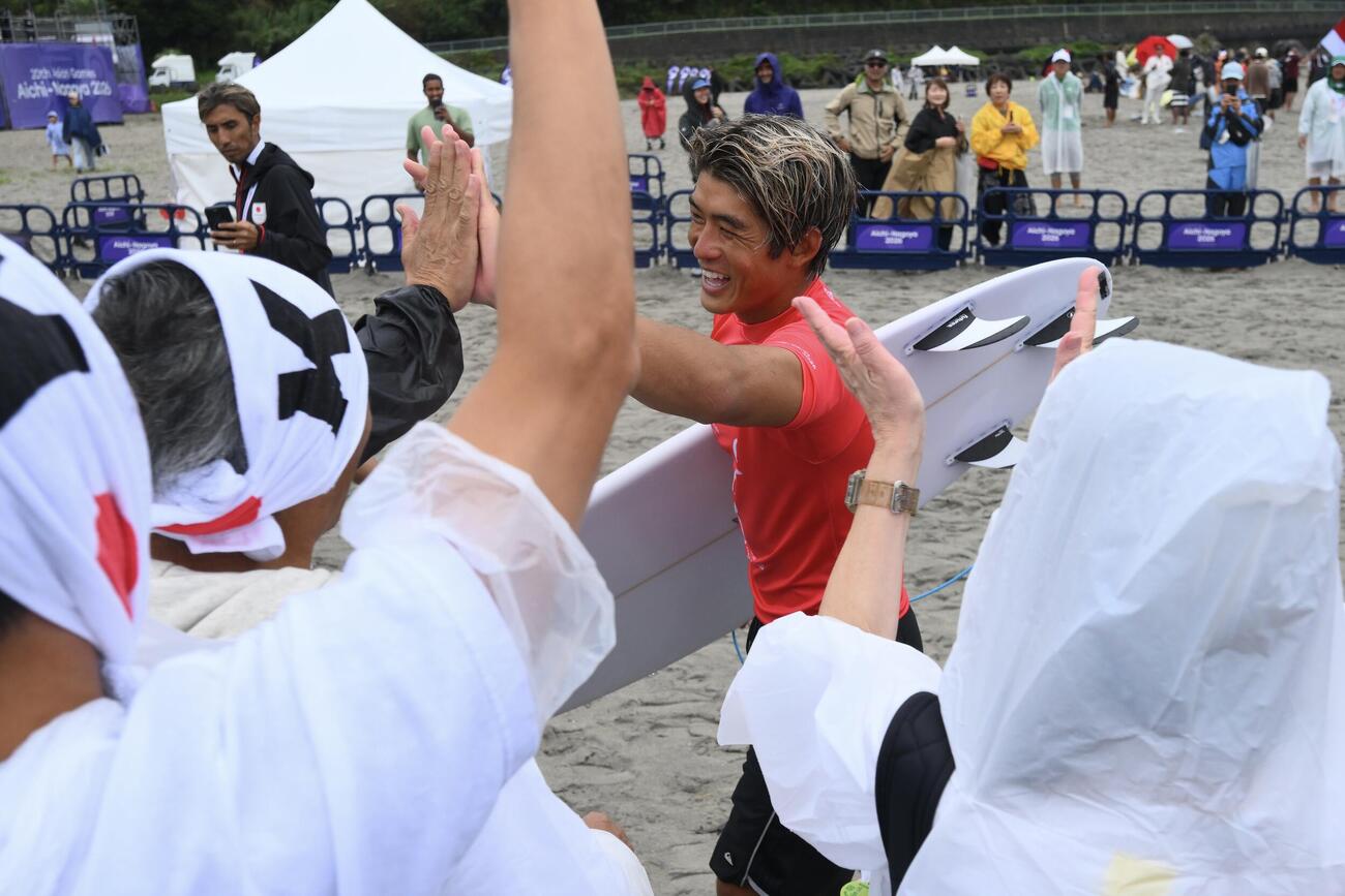 男子サーフィン決勝進出を決めた五十嵐カノアはファンとタッチを交わす（撮影・滝沢徹郎）