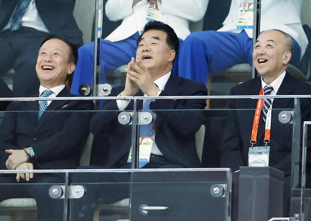 女子高飛び込み決勝を観戦する北朝鮮の金日国体育相（中央）＝29日、東京都江東区の東京アクアティクスセンター（共同）