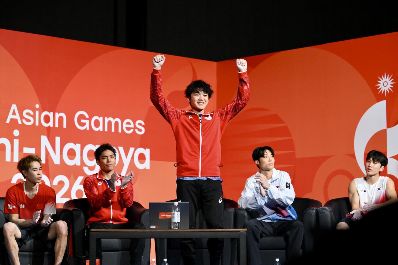 男子ボルダーで優勝を決めガッツポーズする安楽宙斗（中央）。左から2人目は祝福する楢崎智亜（撮影・滝沢徹郎）