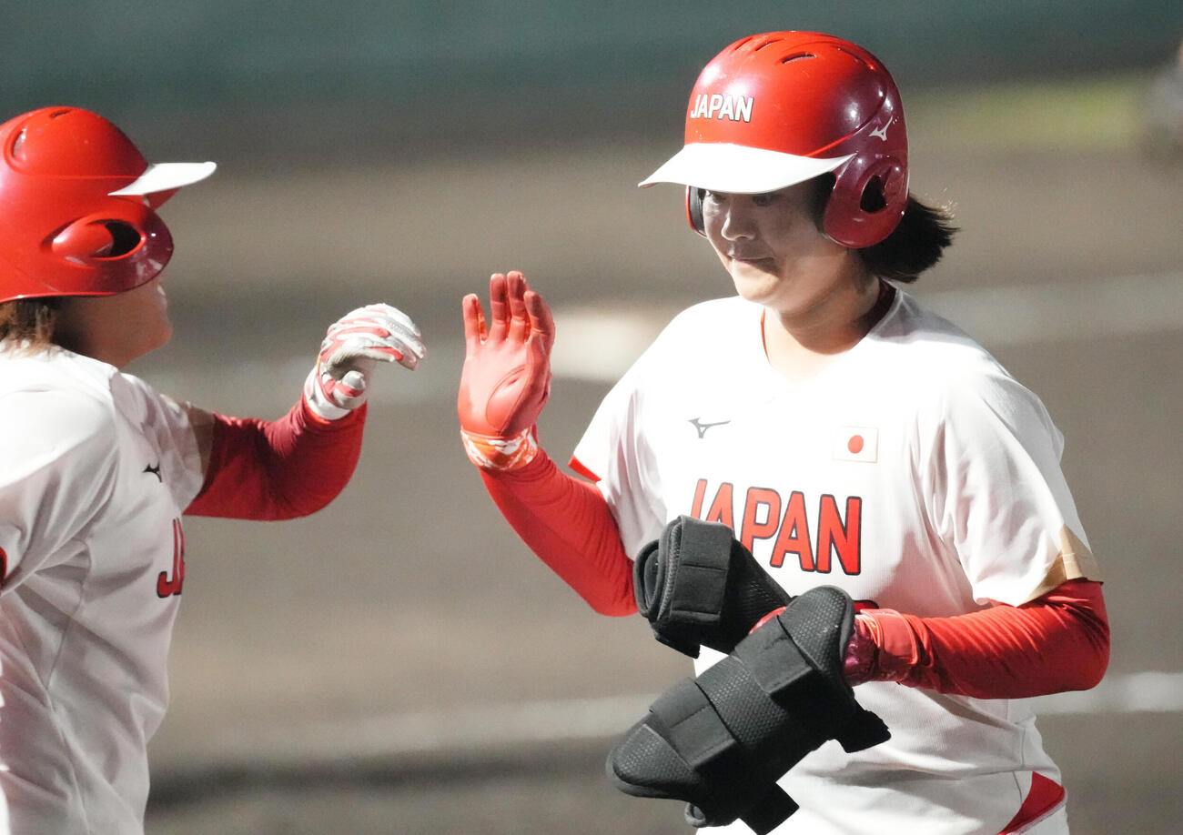 ソフトボール韓国対日本　5回表日本2死一、二塁、日本山内早織（右）は2点適時二塁打を放ちナインとタッチを交わす（撮影・森本幸一）