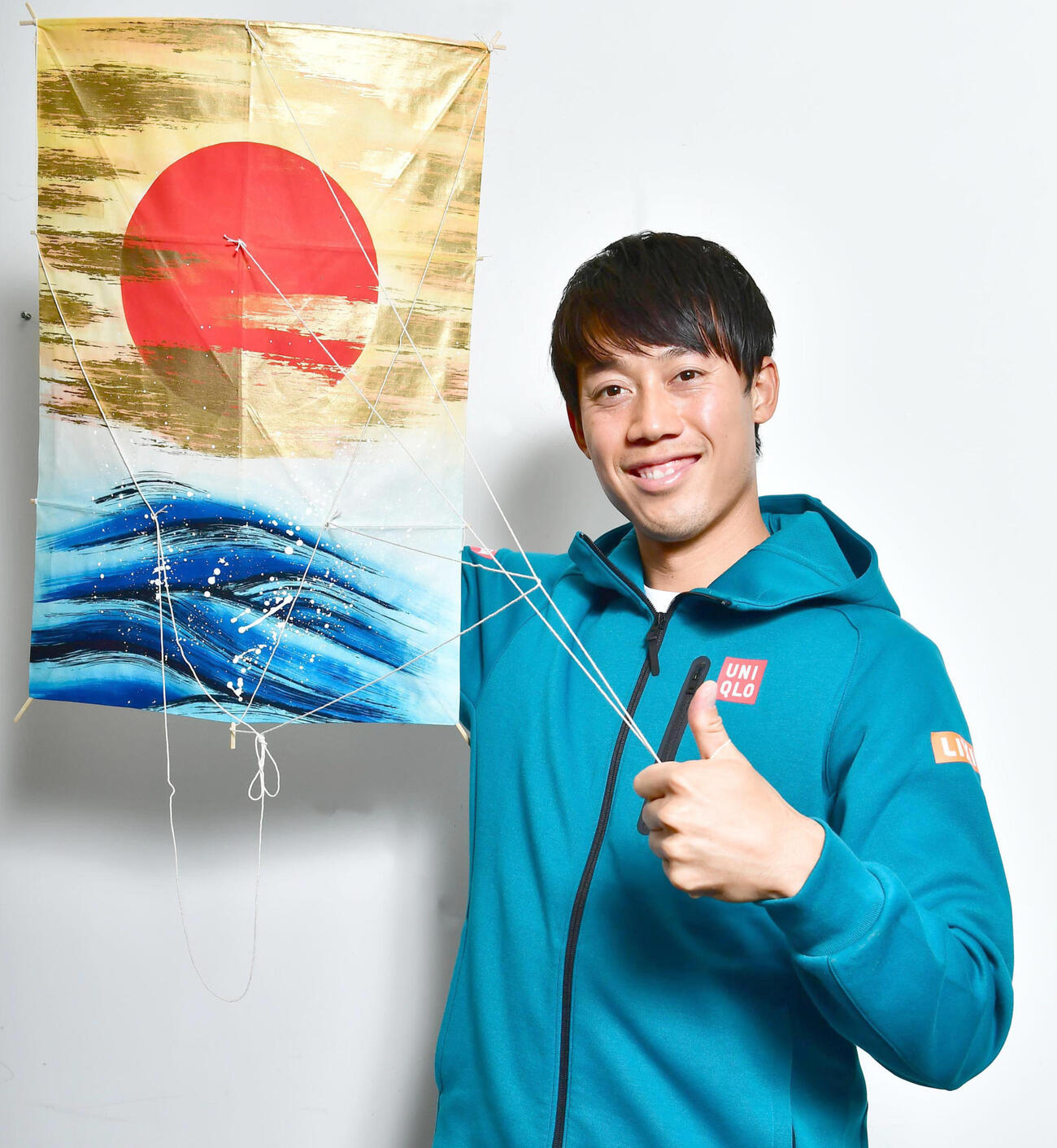 20年12月、黄金色に輝いた雲の切れ間から立ち上る朝日が描かれた和凧を手に、新年への活躍を誓う錦織