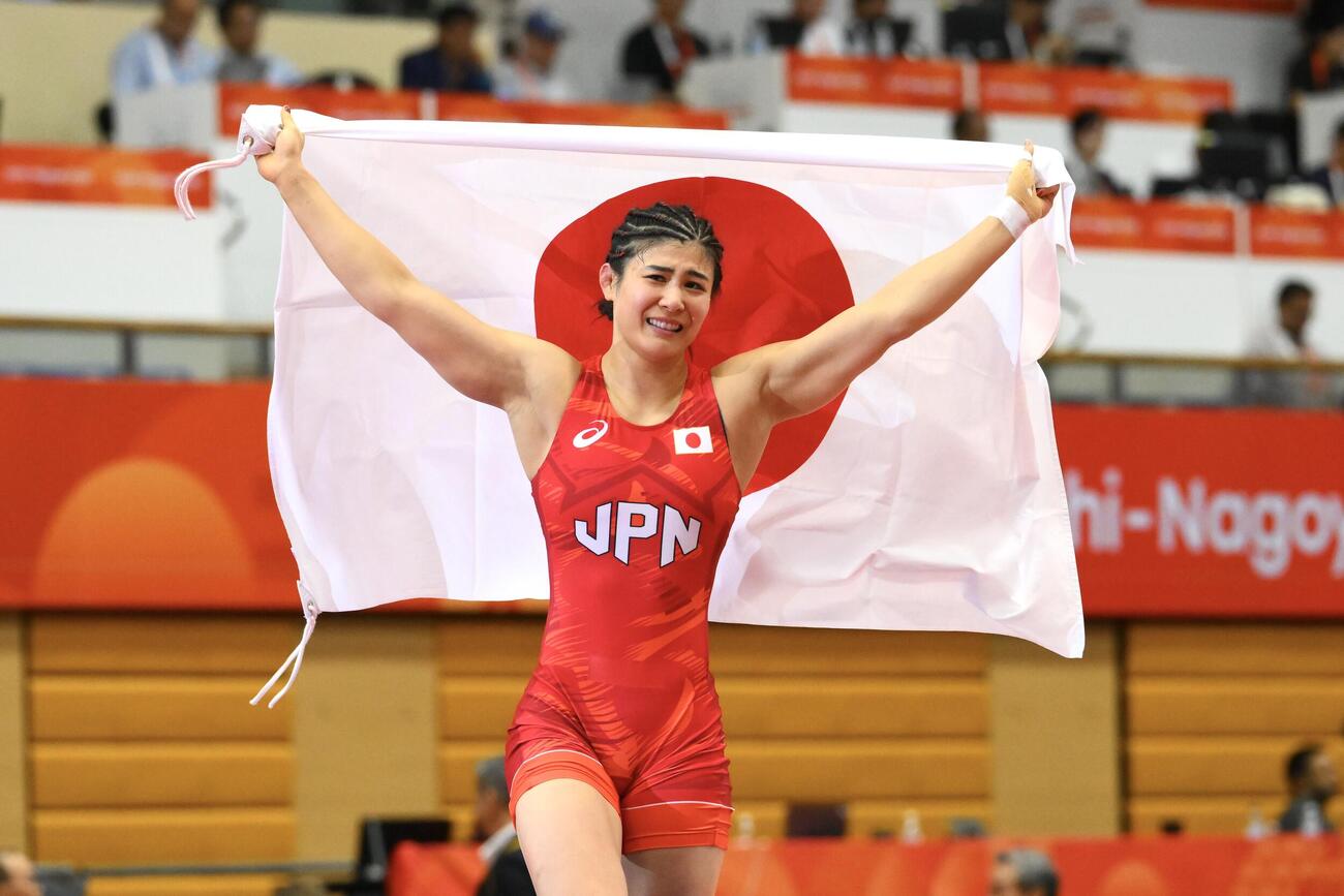 女子62キロ級で優勝を決め日の丸を掲げる尾崎野乃香（撮影・滝沢徹郎）