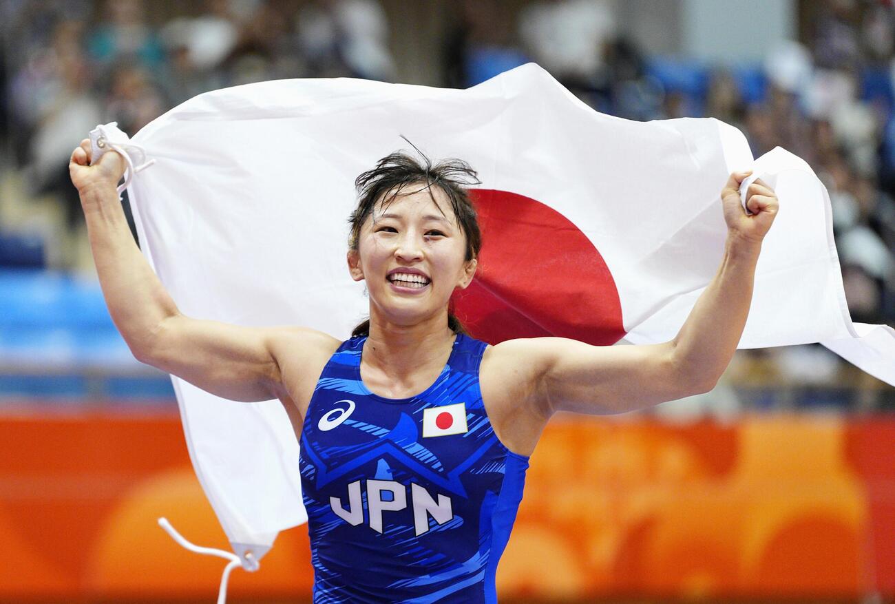 女子50キロ級で優勝し、日の丸を掲げる須崎優衣(共同)