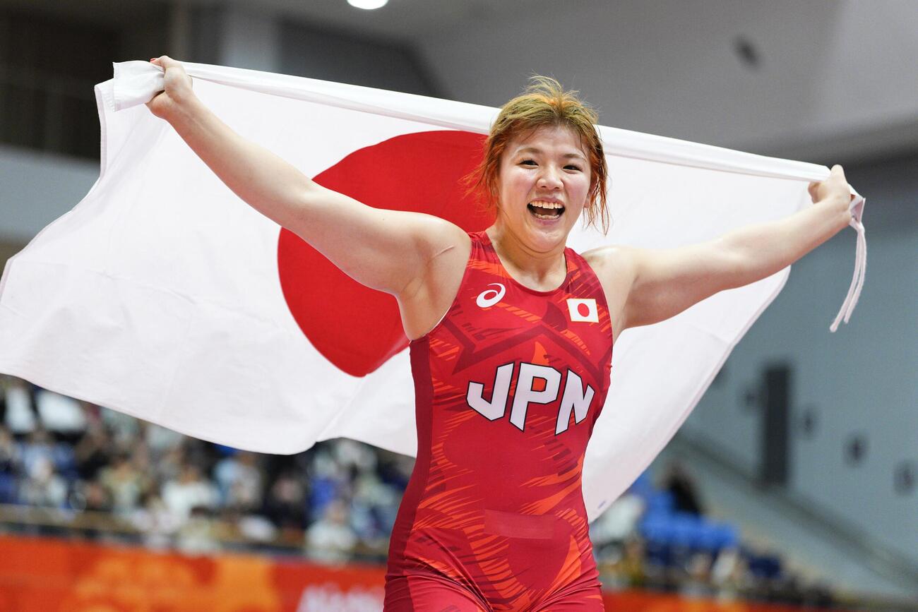 女子76キロ級で優勝し、日の丸を掲げる鏡優翔＝名古屋市稲永SC(共同)