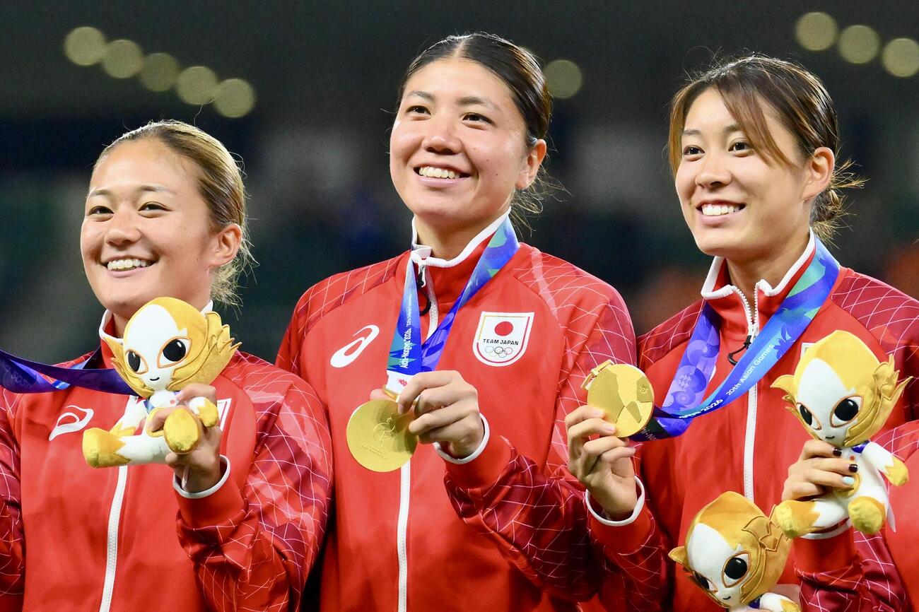 女子サッカー決勝　日本対北朝鮮　表彰式で金メダルを首にかけ笑顔のGK大場朱羽（中央）（撮影・滝沢徹郎）