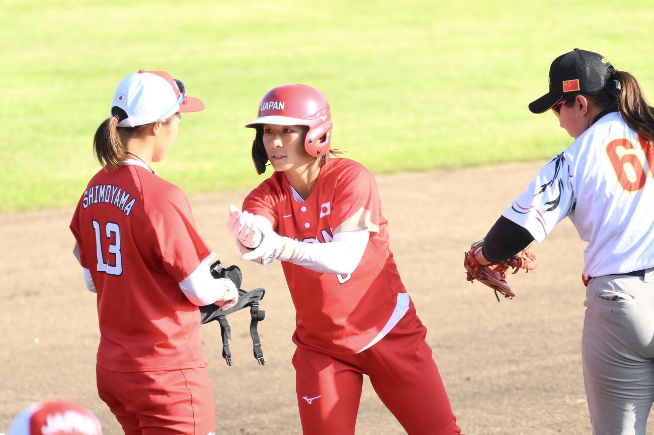 ソフトボール決勝　日本対中国　4回裏に2点適時三塁打を放った石川恭子（中央）（撮影・滝沢徹郎）