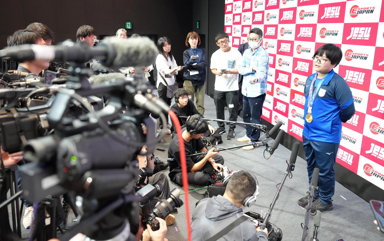 多くの報道陣が集まる中、囲み取材に応じるeスポーツ「ぷよぷよ」の栗原悠輝（撮影・足立雅史）