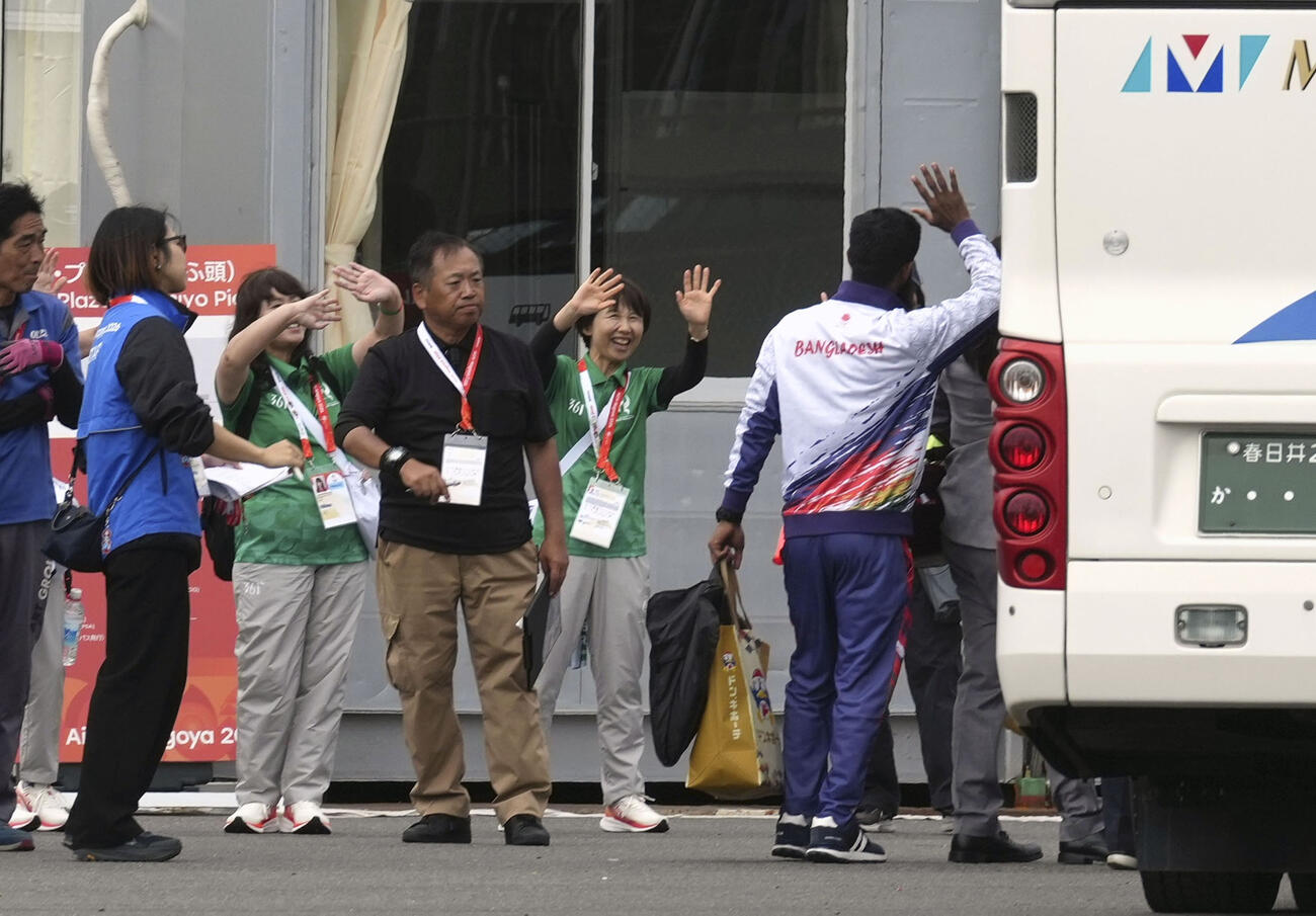 クルーズ船から下船し、帰途に就くバングラデシュ関係者を見送る大会スタッフ＝5日午前、名古屋市（共同）