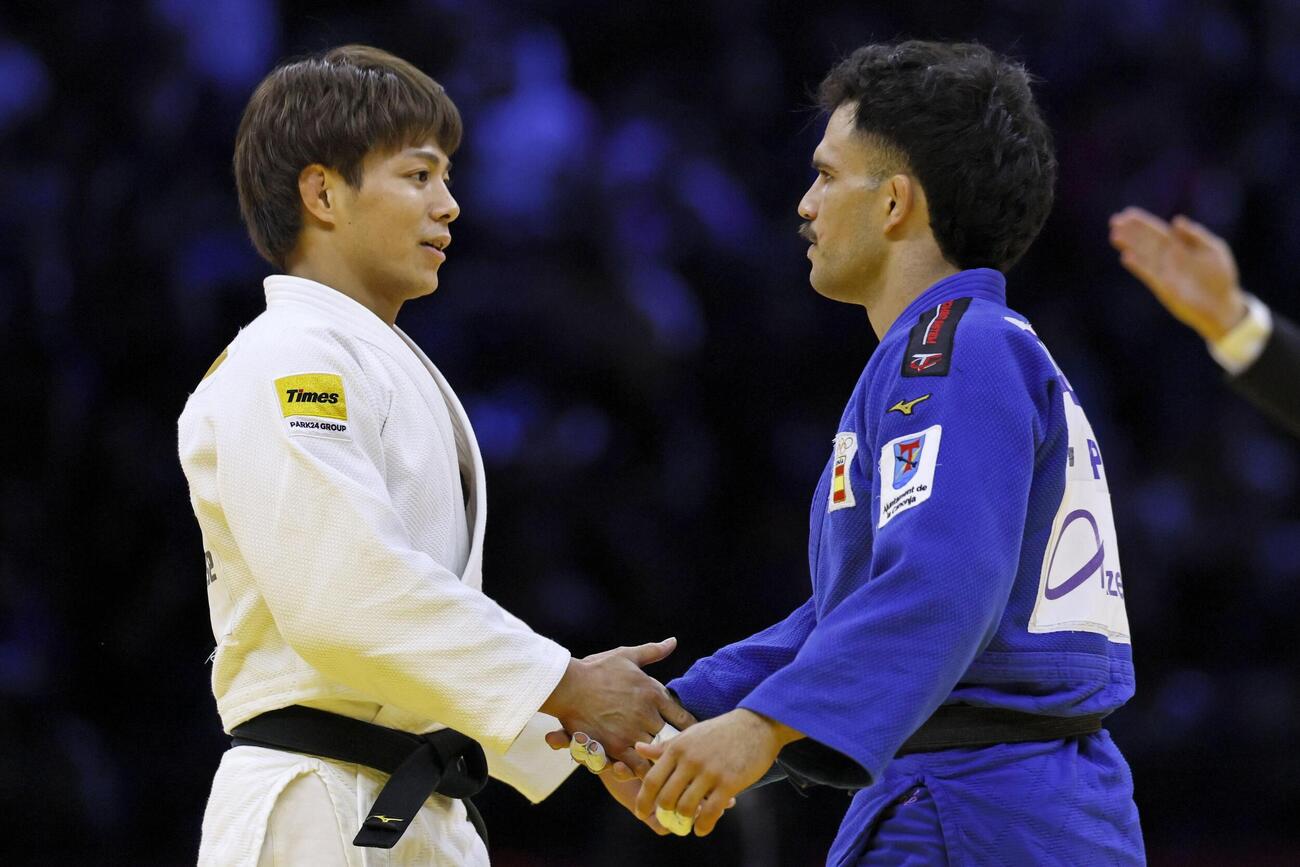 男子66キロ級決勝でダビド・ガルシアトルネ（右）に一本勝ちし、握手を交わす阿部一二三。5度目の優勝を果たした＝バクー（共同）