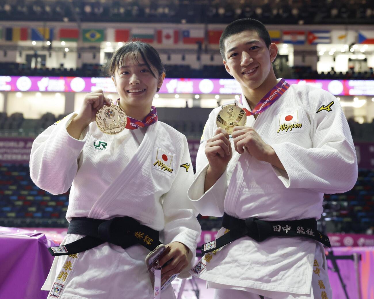 金メダルを手に笑顔を見せる女子57キロ級の大森朱莉（左）と男子73キロ級の田中龍雅（共同）