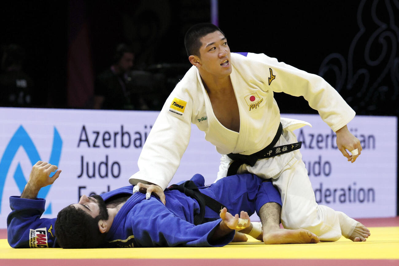 柔道の世界選手権男子73キロ級決勝でUAE選手（左）を破り優勝した田中龍雅（共同）