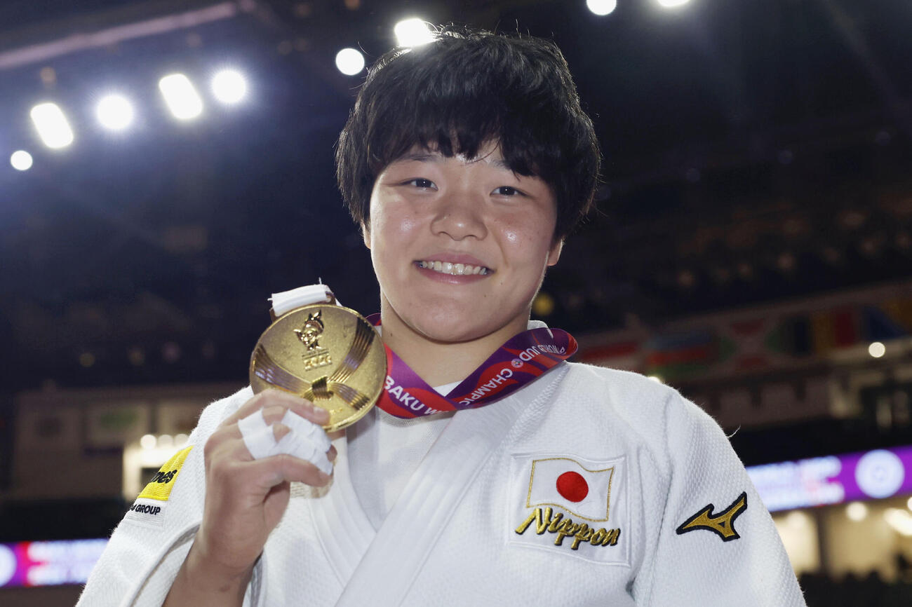 女子63キロ級で優勝し、金メダルを手に笑顔を見せる嘉重春樺（共同）
