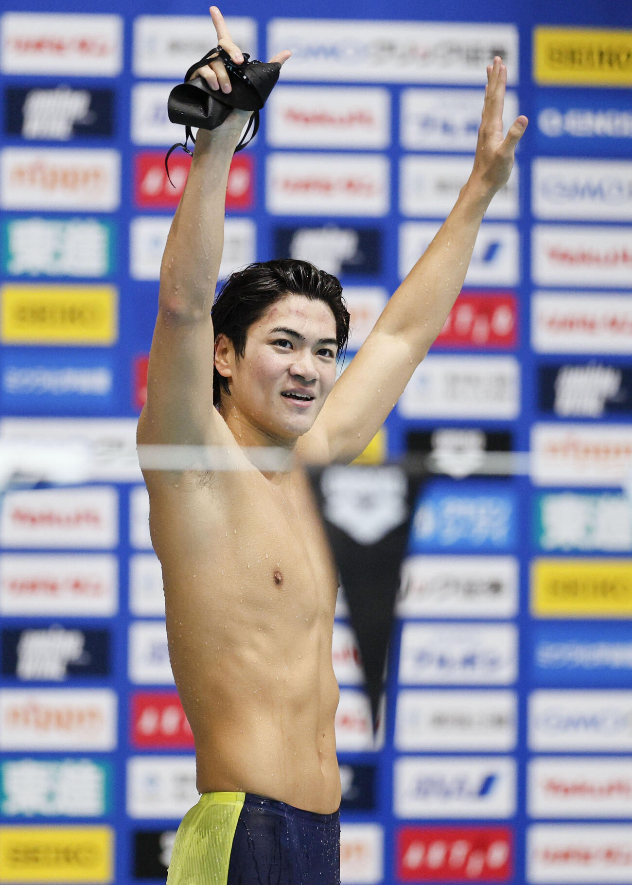 男子400メートル個人メドレーを短水路世界新の3分54秒33で制し声援に応える松下知之（共同）
