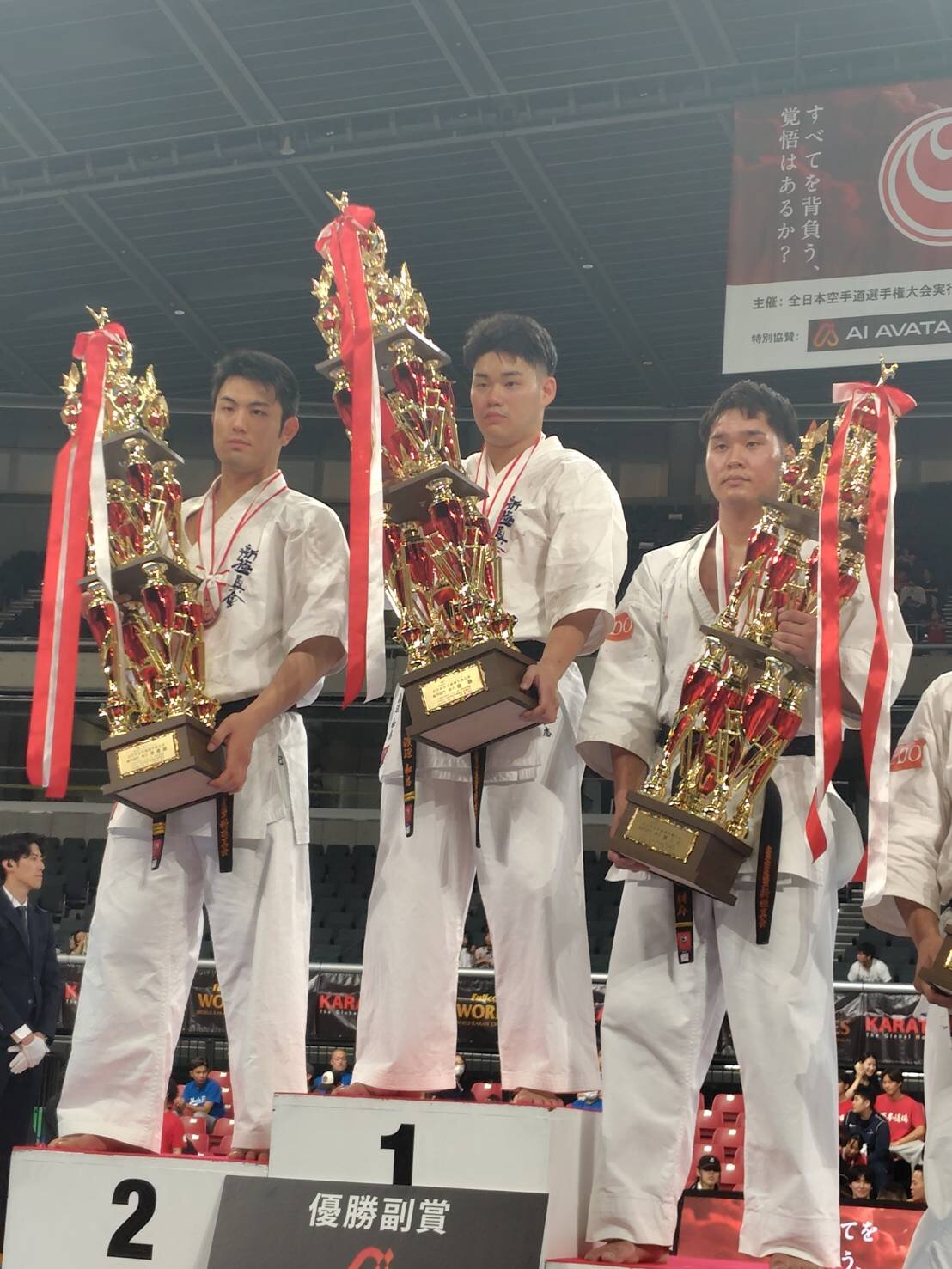 全日本空手道選手権・組手男子の表彰式でトロフィーを掲げる優勝した渡辺和志（中）、準優勝の岡田侑己（左）、第3位の高橋耕介