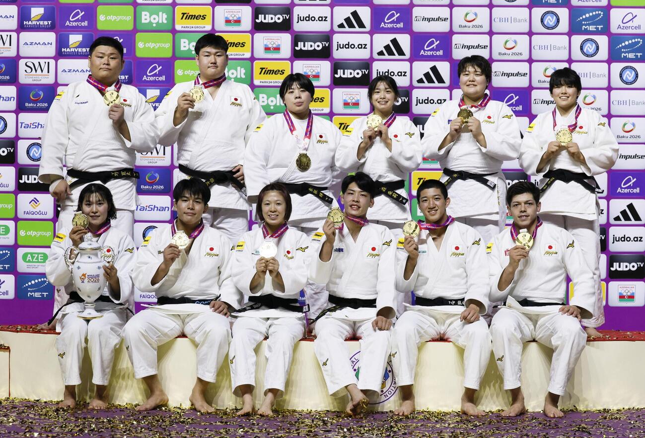 柔道の世界選手権混合団体で8度目の優勝を果たし、金メダルを手に笑顔の、前列左から田中志歩、田嶋剛希、玉置桃、内村秀資、田中龍雅、村尾三四郎、後列左から中野寛太、中村雄太、素根輝、大森朱莉、新井万央、前田凜（11日＝共同）