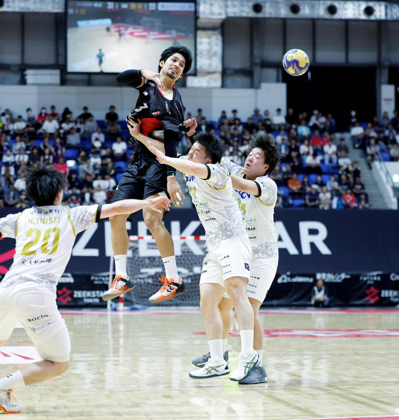 ジークスター東京対富山ドリームス　後半、囲まれながらパスを出すジークスター東京部井久アダム勇樹（左）（撮影・山本朝陽）