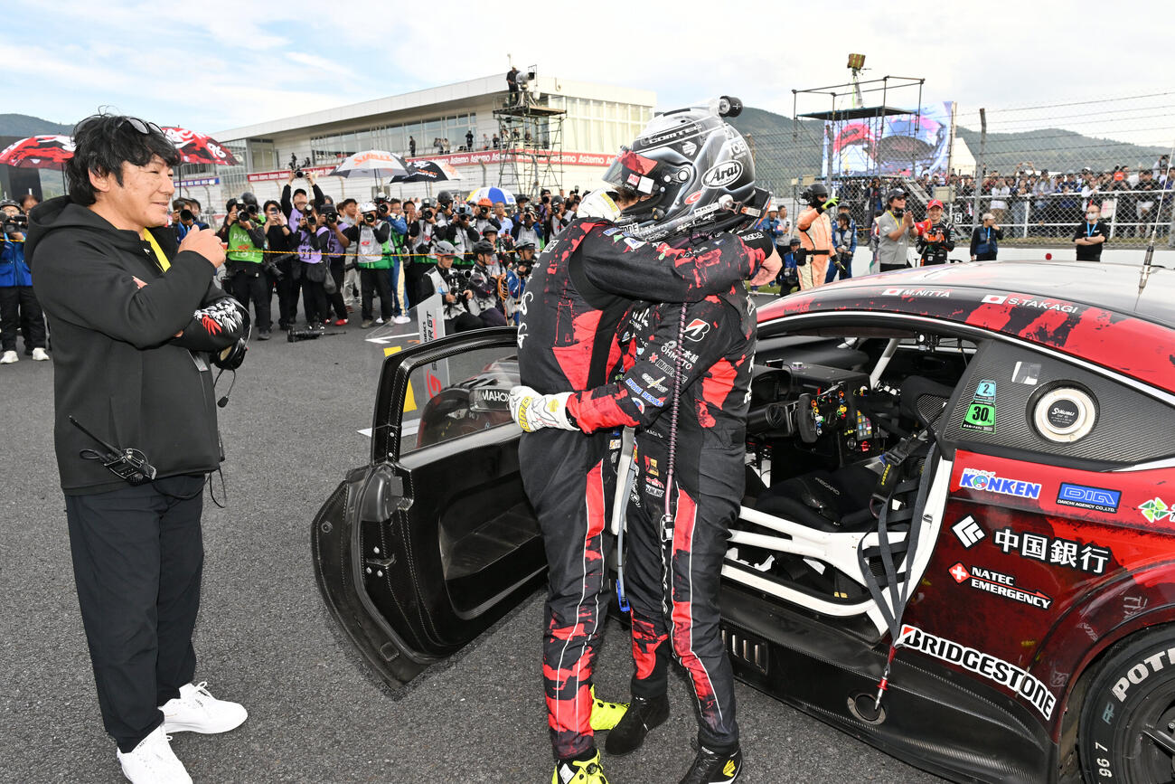GT300クラスで優勝して抱き合う高木、新田と喜ぶ影山正彦監督（右から＝GTA提供）
