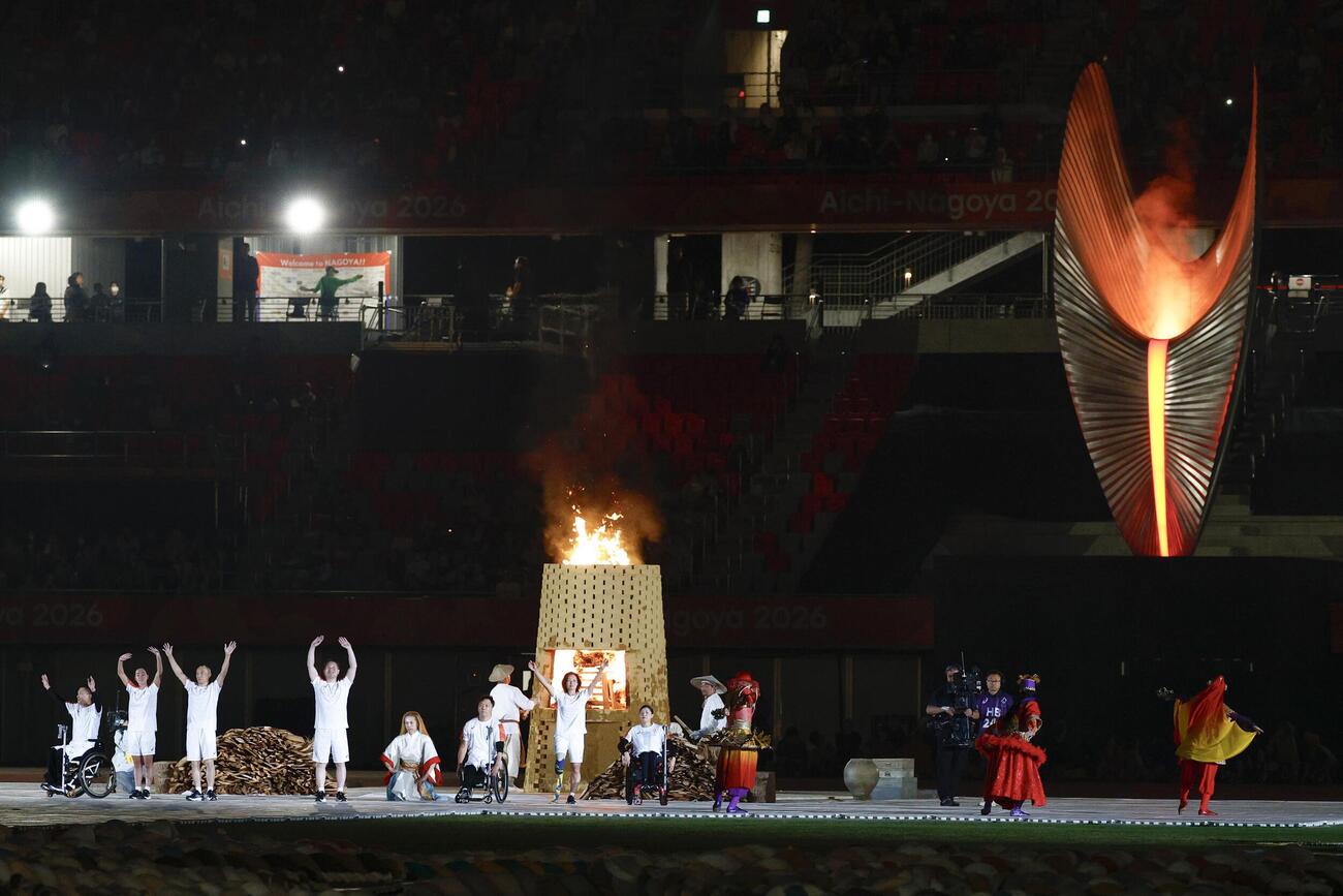 開会式で点火された聖火台とリレー最終走者ら＝18日、パロマ瑞穂スタジアム（共同）