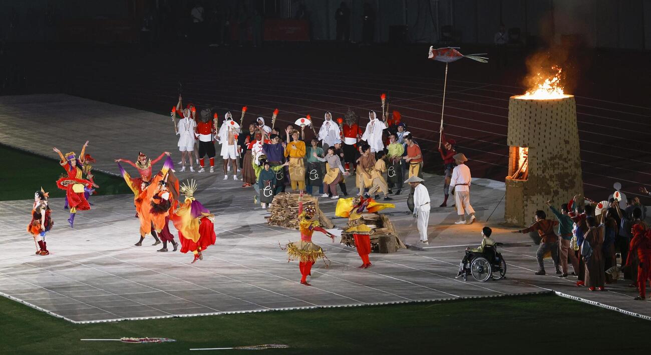 開会式で点火された聖火台と披露されたパフォーマンス＝18日、パロマ瑞穂スタジアム（共同）