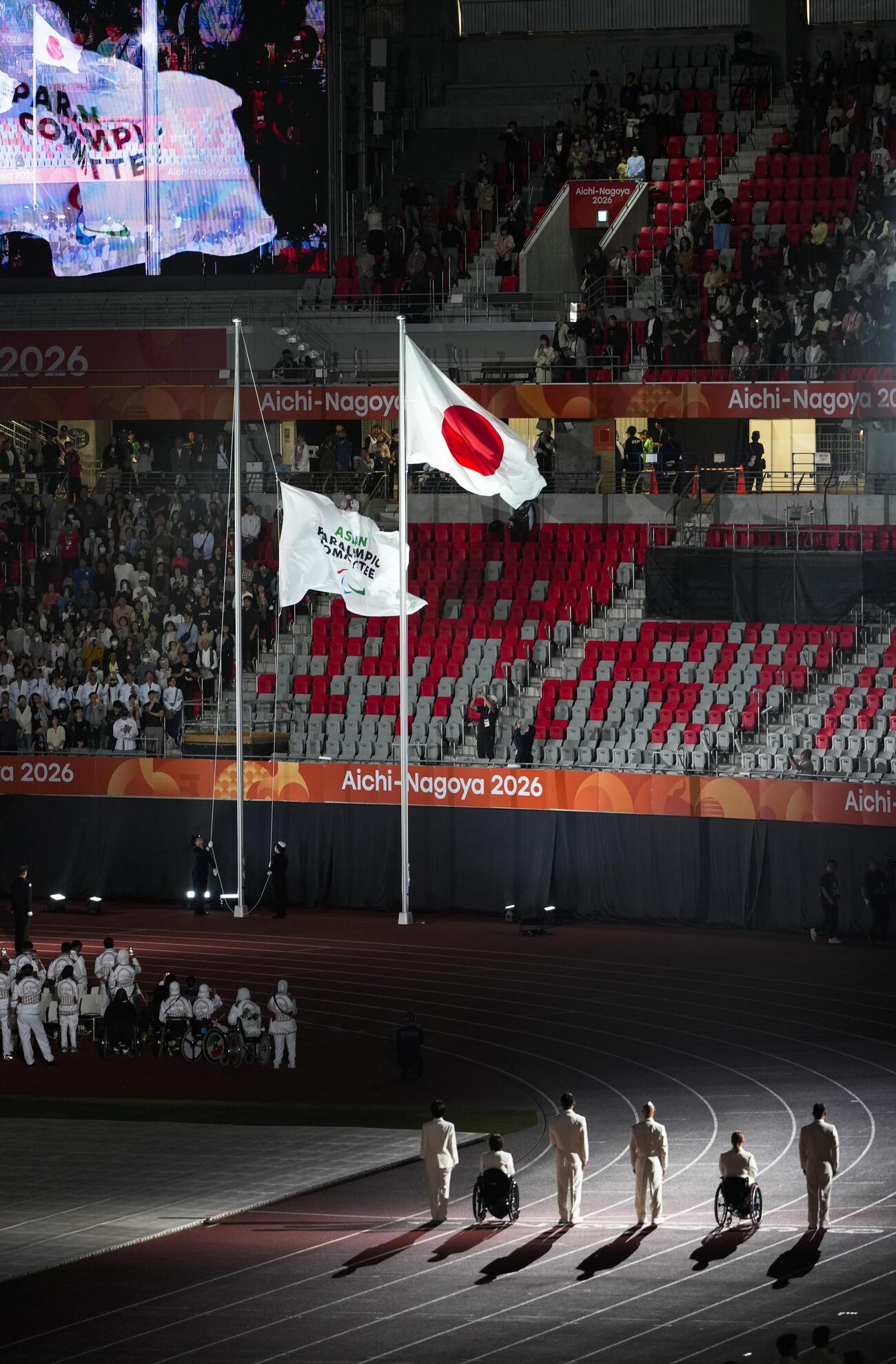 開会式で掲揚された日の丸と大会旗＝18日、パロマ瑞穂スタジアム（共同）