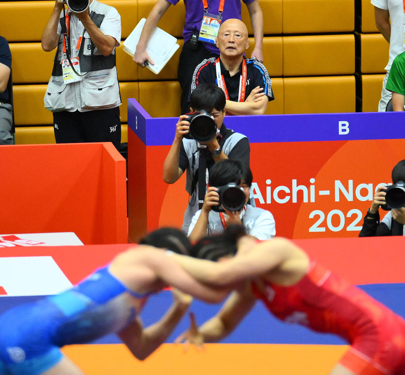 10月1日、愛知・名古屋アジア大会で女子62キロ級尾崎野乃香（手前右）と対戦するモンゴルの選手を見守る栄和人総監督（後方）（撮影・滝沢徹郎）