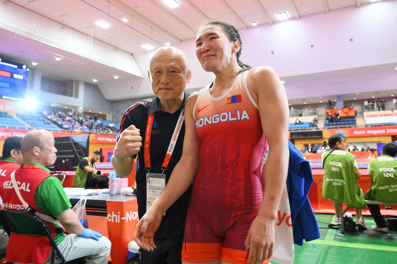 愛知・名古屋アジア大会レスリング女子62キロ級でモンゴルのトグトフ・アルトジン（右）が銅メダルを獲得しガッツポーズのの栄和人総監督（撮影・滝沢徹郎）