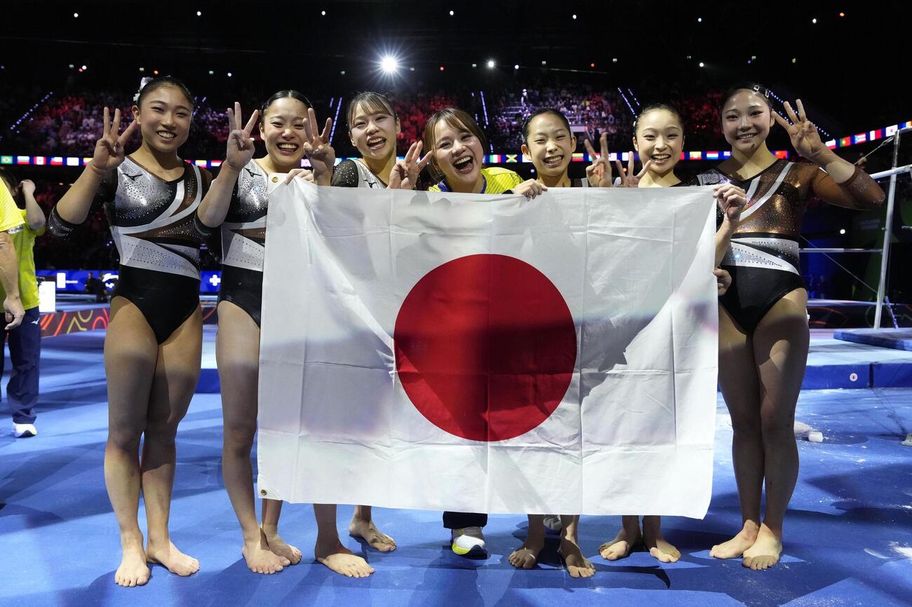 体操世界選手権の女子団体総合で銅メダルを獲得し喜ぶ日本の選手ら。ロサンゼルス五輪の切符を手にした＝21日、オランダ・ロッテルダム（共同）