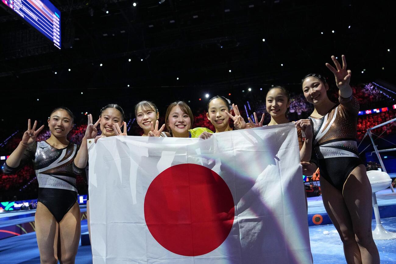 銅メダルを決め、日の丸を掲げる日本女子チーム（AP）