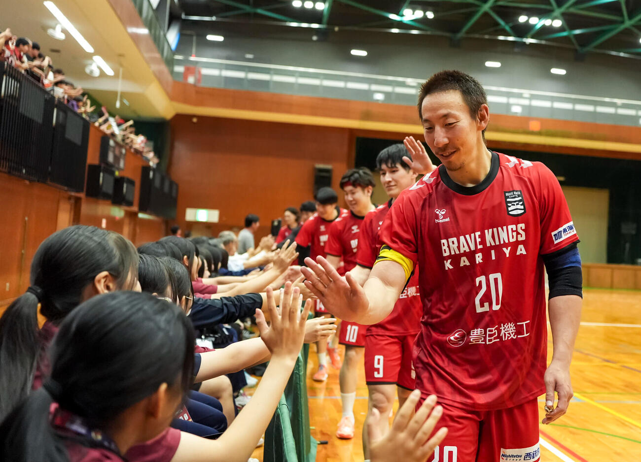 試合後、ファンとタッチを交わすRB渡部仁主将（C）ブレイヴキングス刈谷
