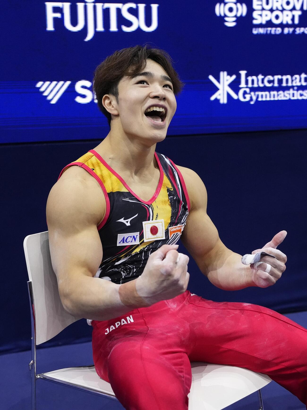 男子種目別鉄棒決勝の得点を確認し、笑顔の岡慎之助＝ロッテルダム（共同）