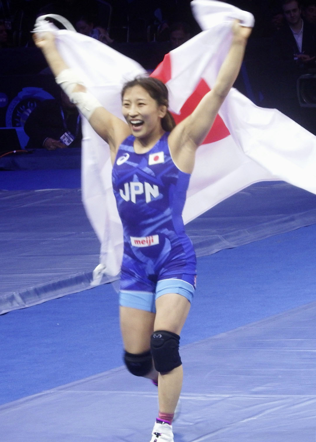 女子50キロ級で優勝し日の丸を掲げて喜ぶ須崎優衣＝アスタナ（共同）