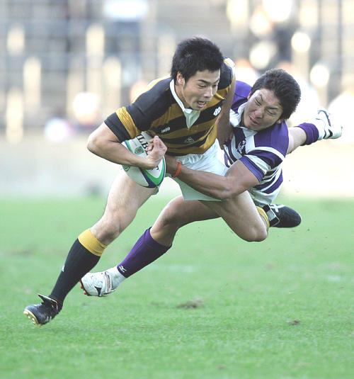 07年11月、慶大WTB山田(左)は明大WTB星野のタックルを受けながら突進する
