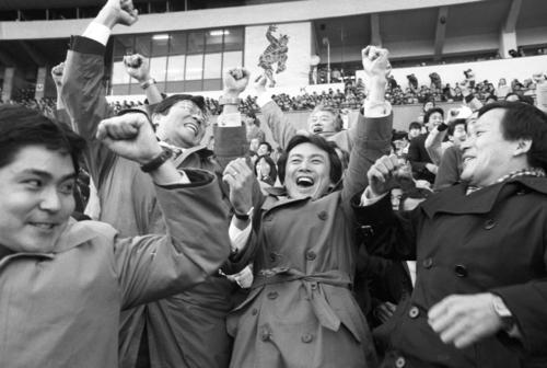 86年1月、日本選手権でトヨタを下し、スタンドで喜ぶ慶大・上田監督(中央)