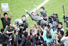 初優勝し選手に胴上げされる東福岡の谷崎重幸監督。左の遺影は大会直前に事故死した広木淳選手（共同）
