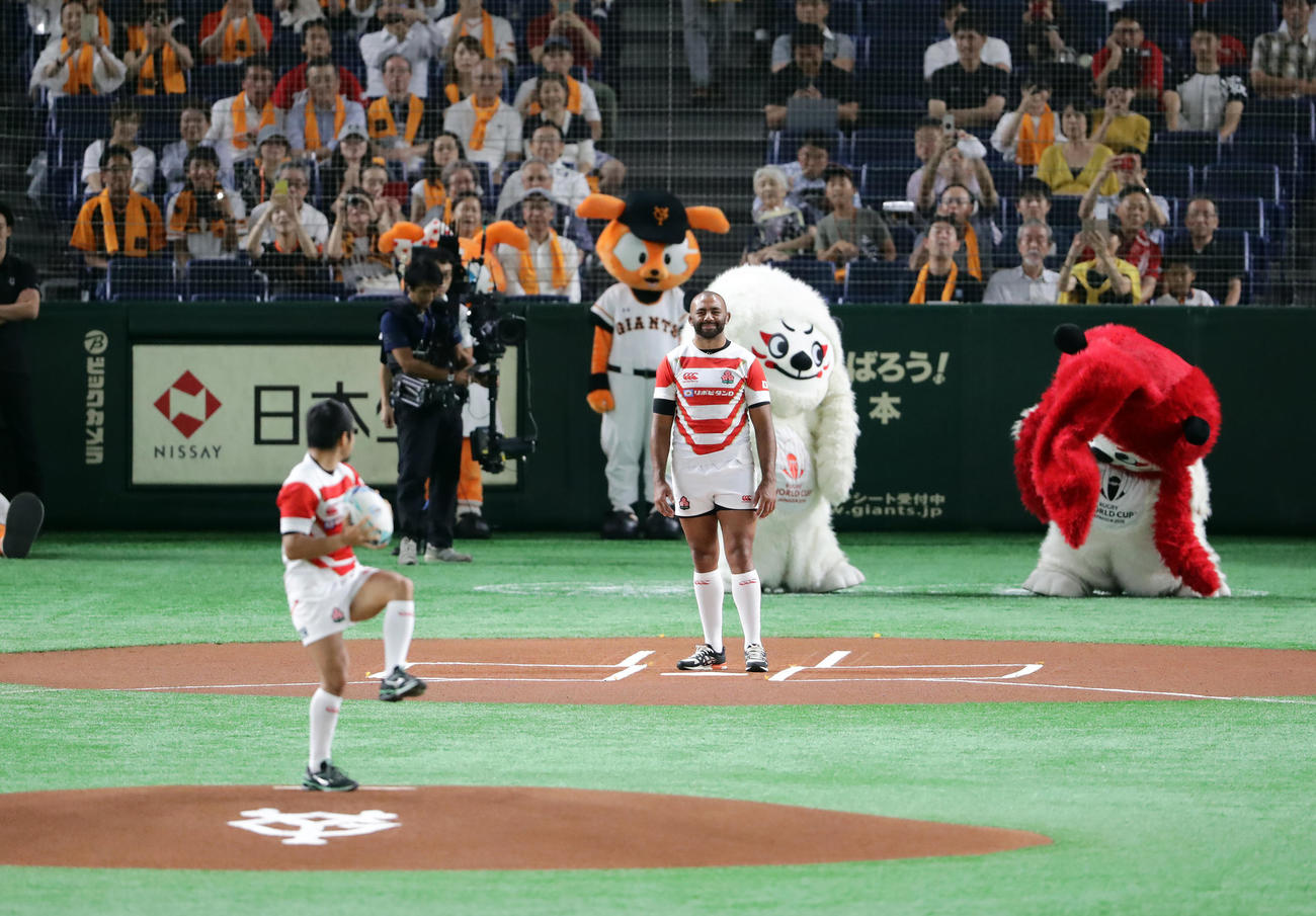 巨人対広島　始球式に登場しラグビーボールで投げるラグビー日本代表の田中（手前）と受けるリーチ・マイケル（撮影・浅見桂子）