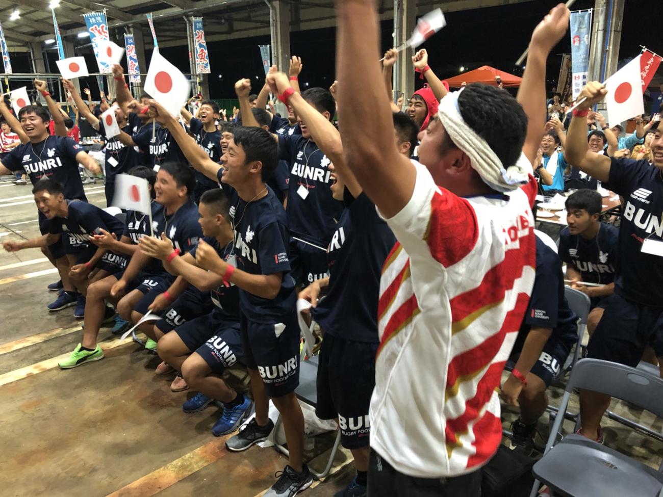 魚市場で実施したサモア戦のPVで歓声を上げる佐伯市民