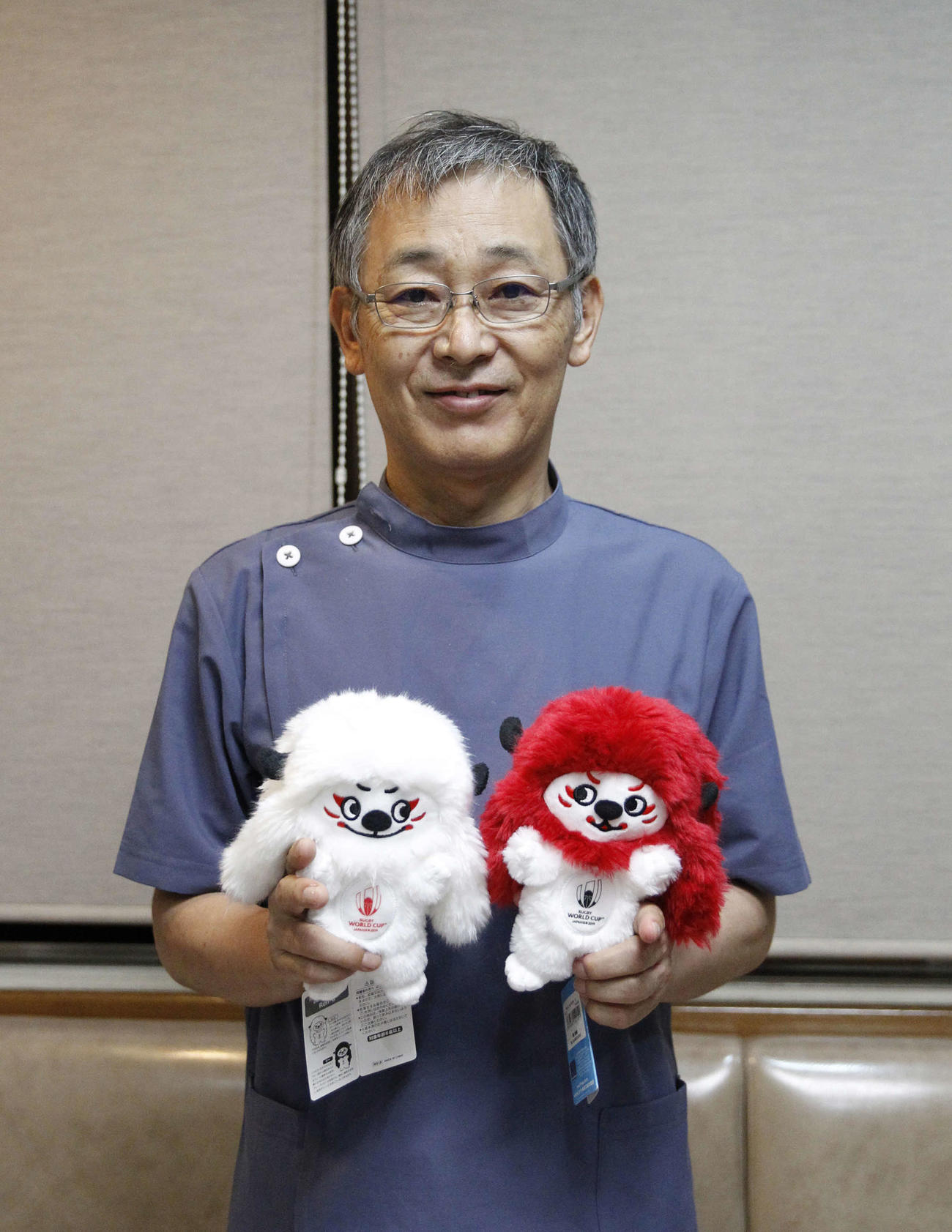 日本代表のキャラクターグッズを手にエールを送るWTB福岡堅樹の父綱二郎さん