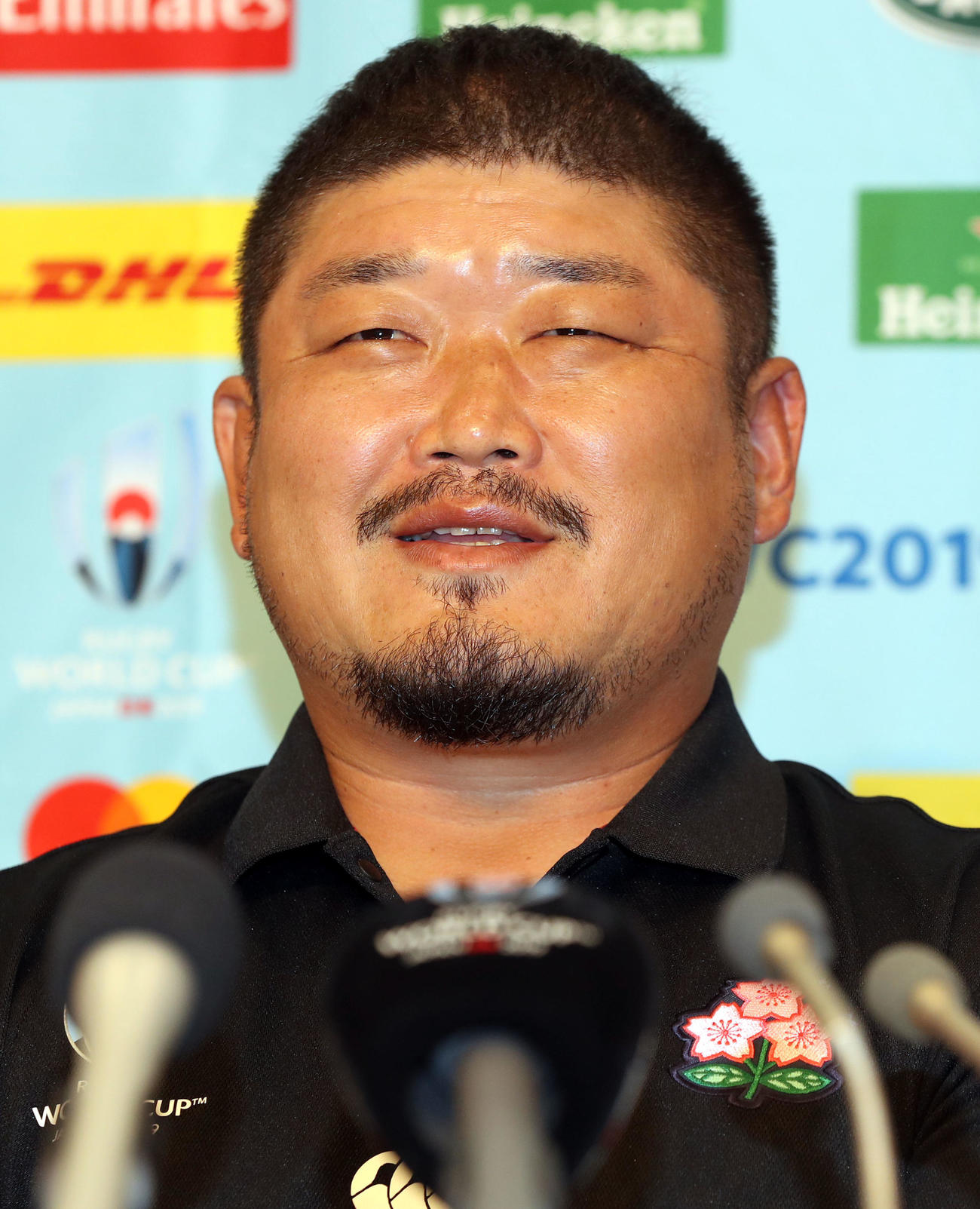 会見で笑顔を見せる長谷川スクラムコーチ（撮影・狩俣裕三）